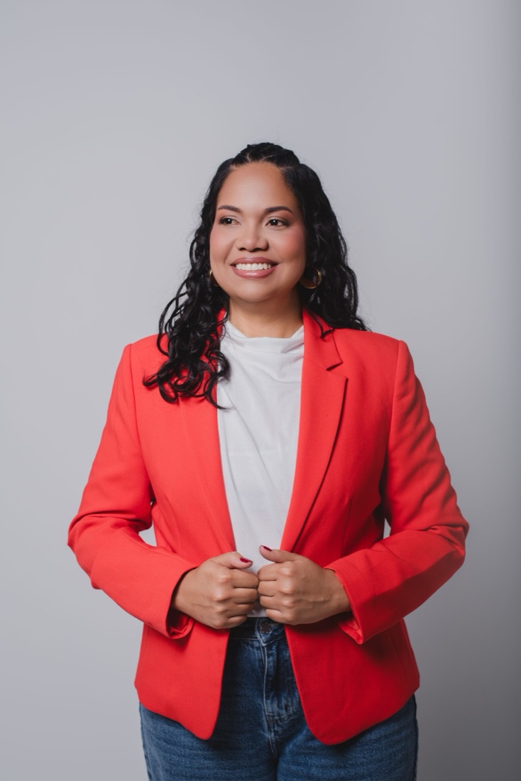 Eunice López, con saco rojo, sonriendo